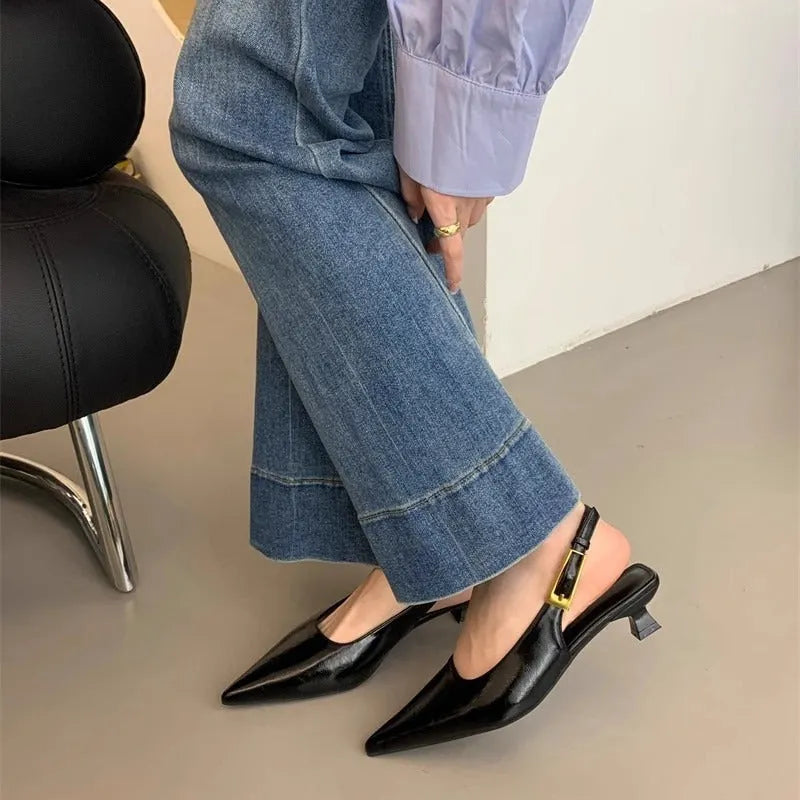 Women's black leather pointed toe shoes with low heel and thin strap.