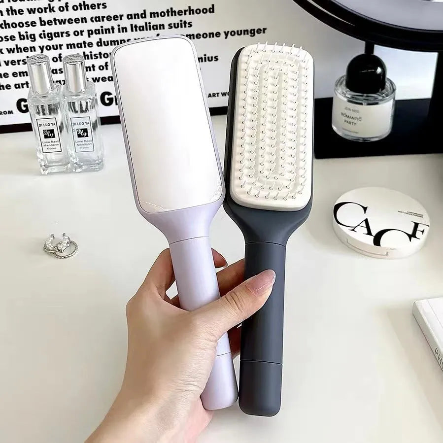 Purple and grey self-cleaning hair brush with rotating handle for easy debris removal