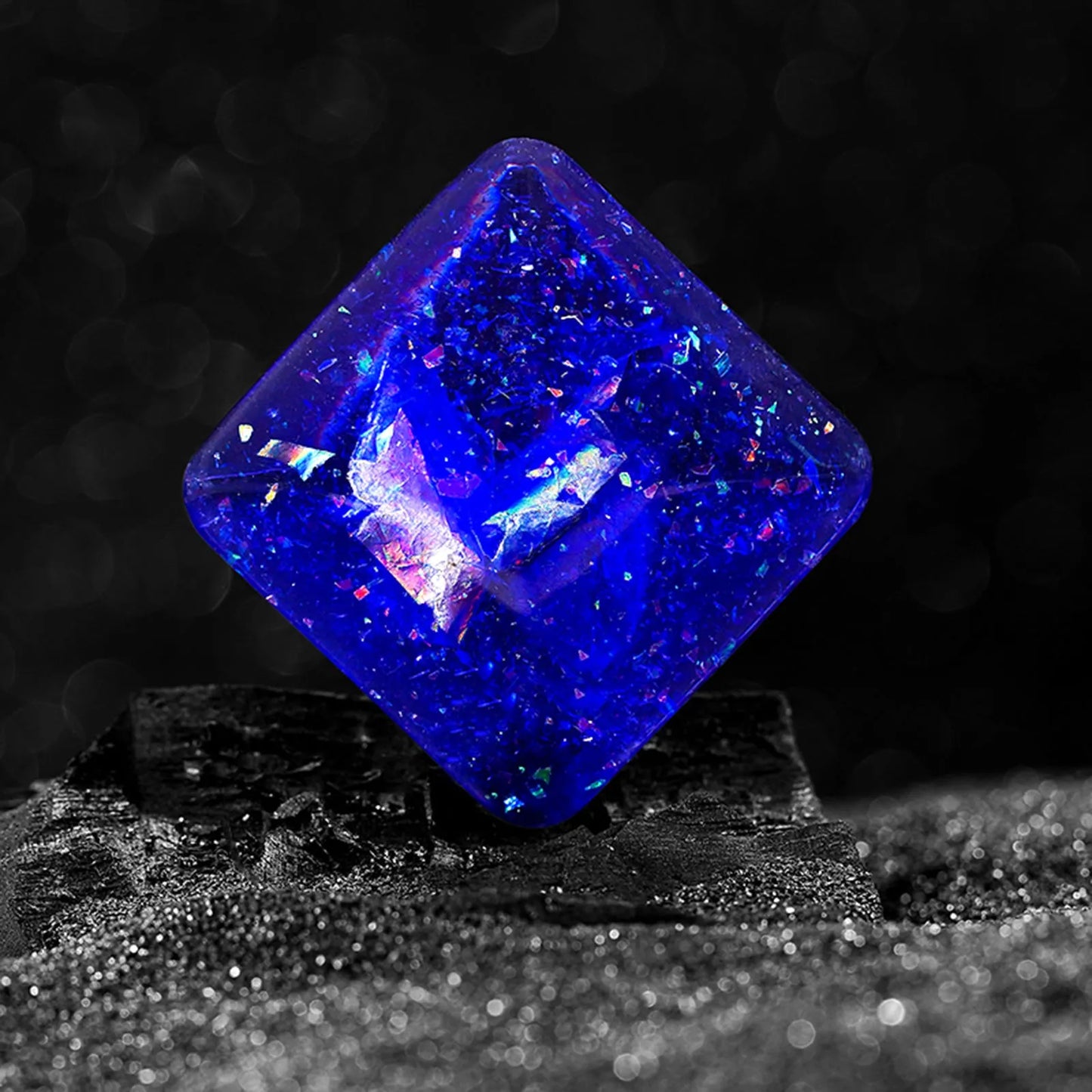 Galactic edition pocket gyro desk toy on a surface, showing its quadrilateral resin construction and celestial colour design.