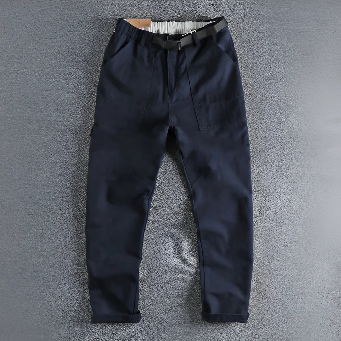 Men's khaki work trousers with a three-dimensional cut and an N I buckle belt on a hanger.