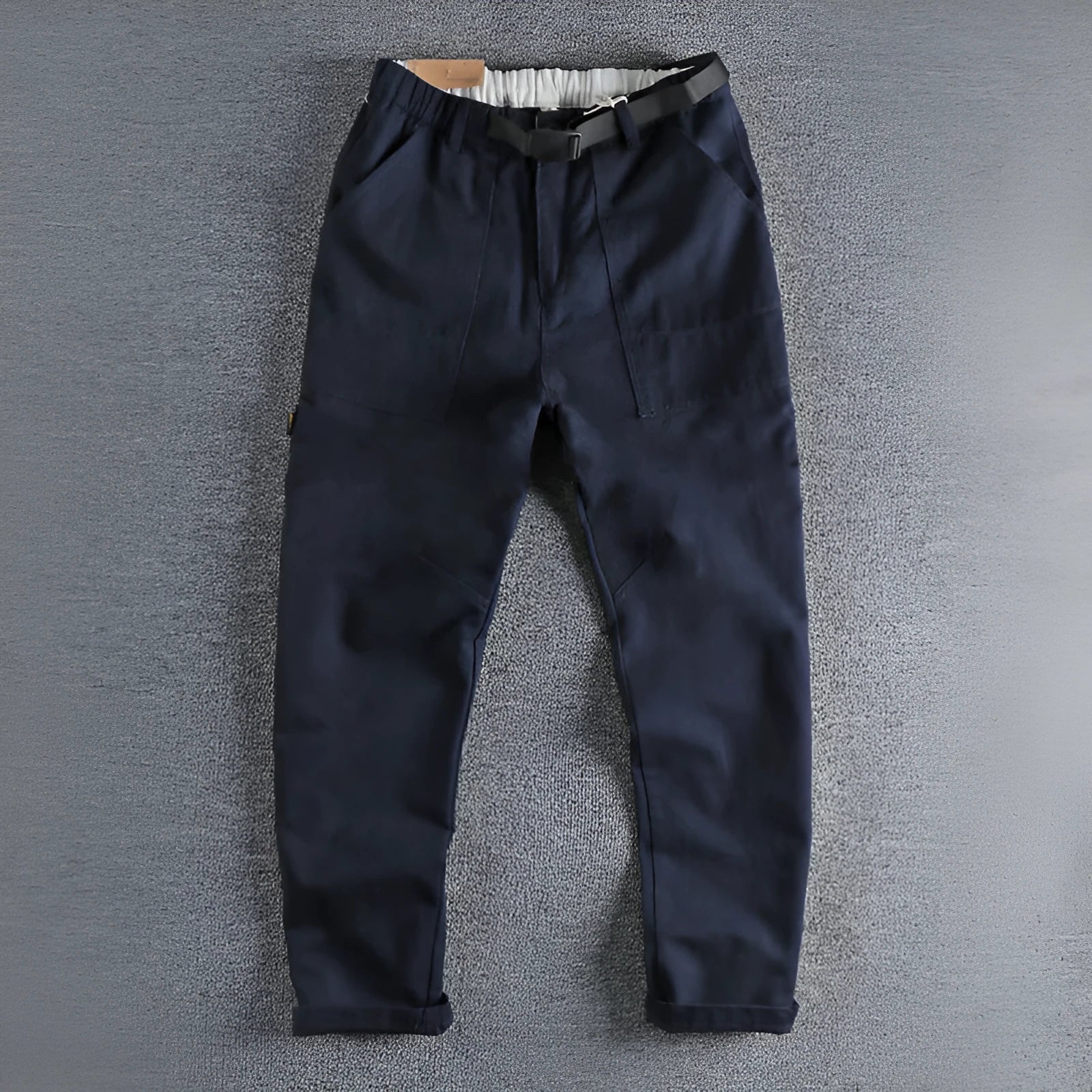 Men's khaki work trousers with a three-dimensional cut and an N I buckle belt on a hanger.