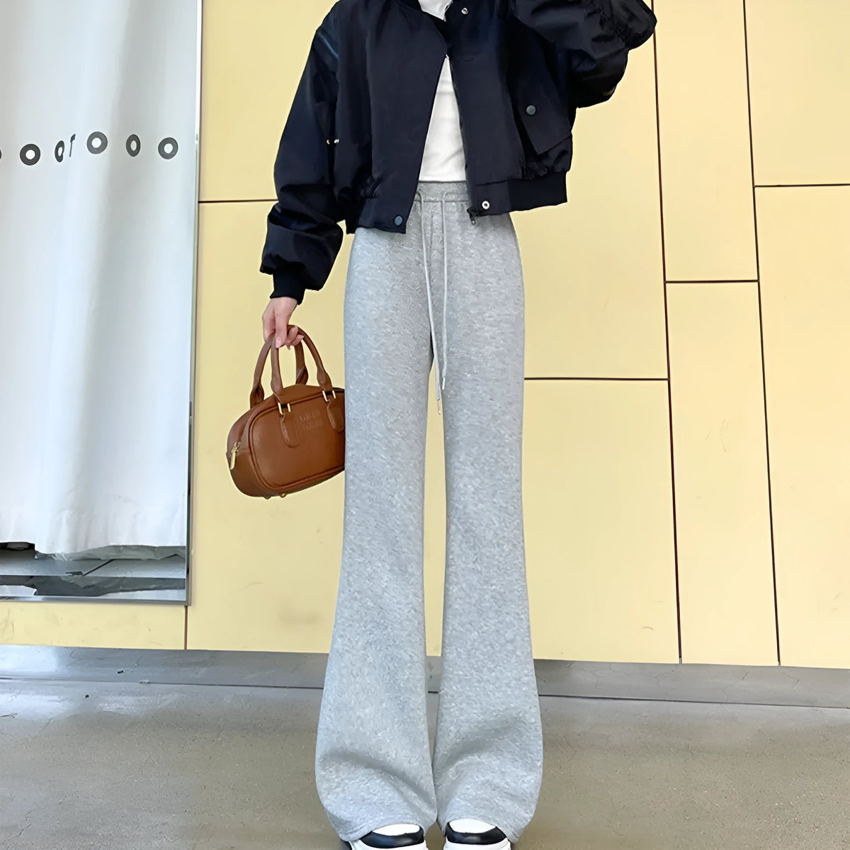 Women's high waist bootcut sports pants in black cotton with fleece lining and micro elasticity, slightly flared leg.
