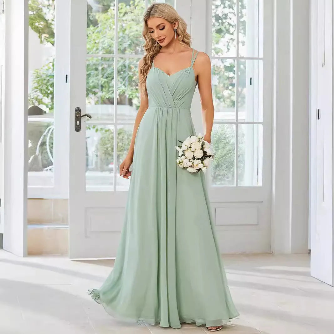 Woman wearing a light green sleeveless dress with a long pleated A-line skirt.