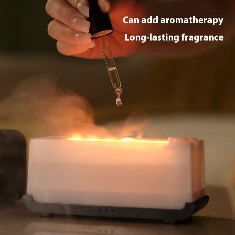 White USB aroma diffuser with glowing flame simulation and mist output on a wooden table.