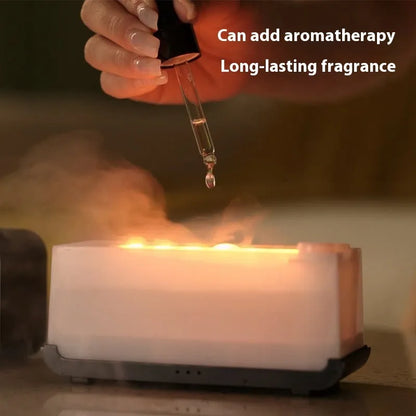 White USB aroma diffuser with glowing flame simulation and mist output on a wooden table.