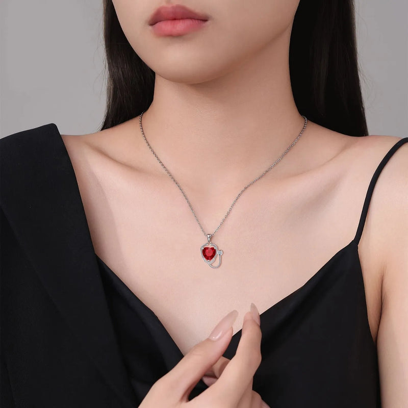 Women's fashion necklace with wings and cross stethoscope pendant in red diamond colour, casual style electroplated copper jewellery accessory with detailed pendant design for female wearers, includes one necklace in the set