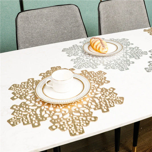Snowflake-patterned heat-resistant placemats in gold and silver colors, ideal for holiday table settings and decor
