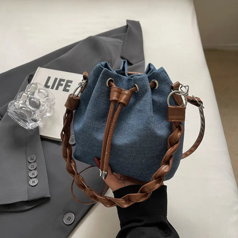 Blue cross body bucket bag with synthetic leather lining and adjustable shoulder strap