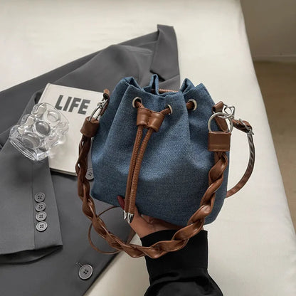 Blue cross body bucket bag with synthetic leather lining and adjustable shoulder strap