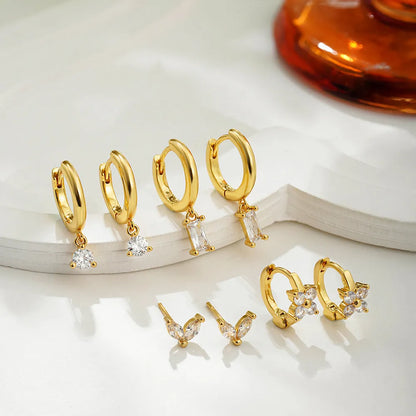 Set of four pairs of geometric copper earrings with zircon stones in gold or silver electroplated finish.