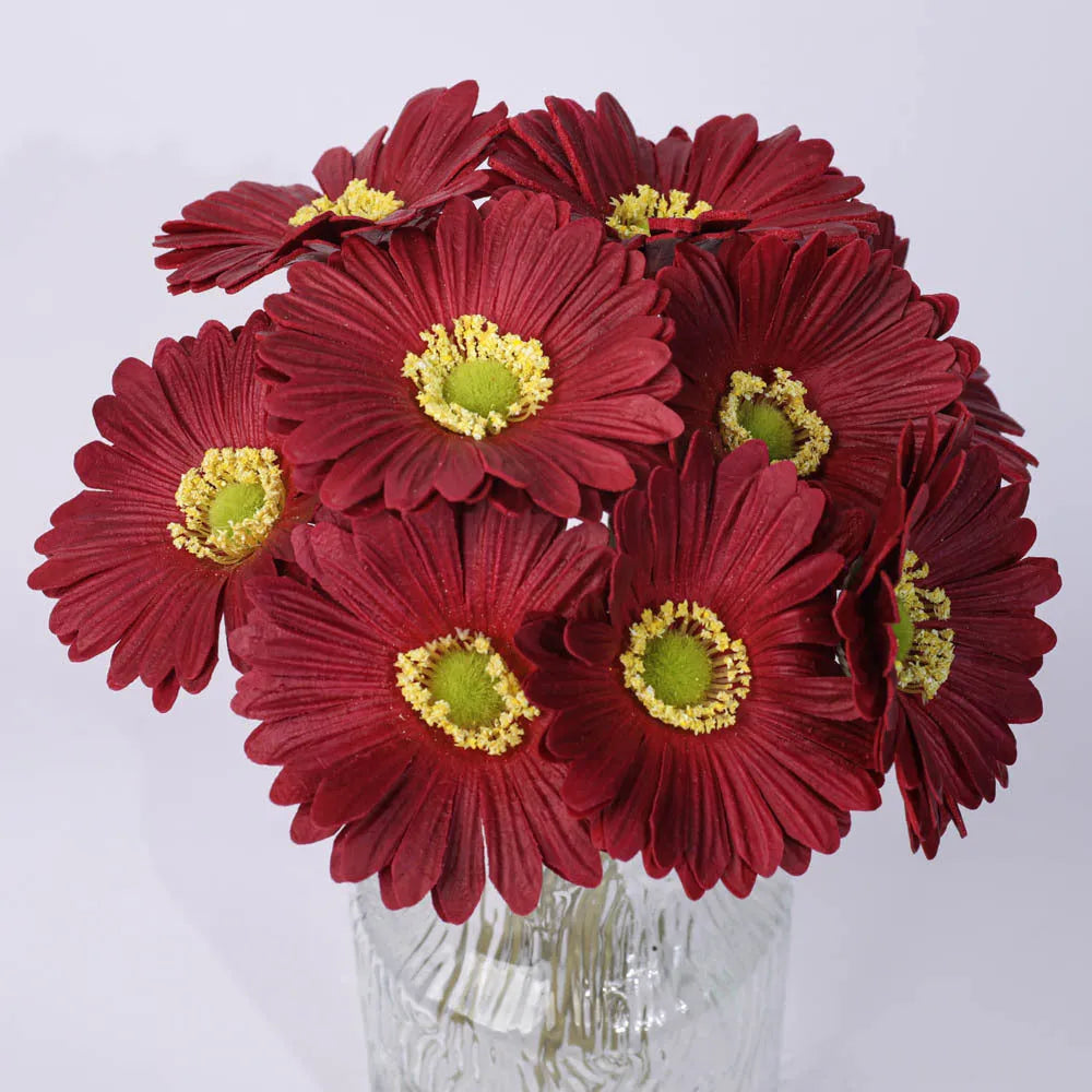 Silk artificial flower bouquet in a white polyurethane pot on a wooden table.
