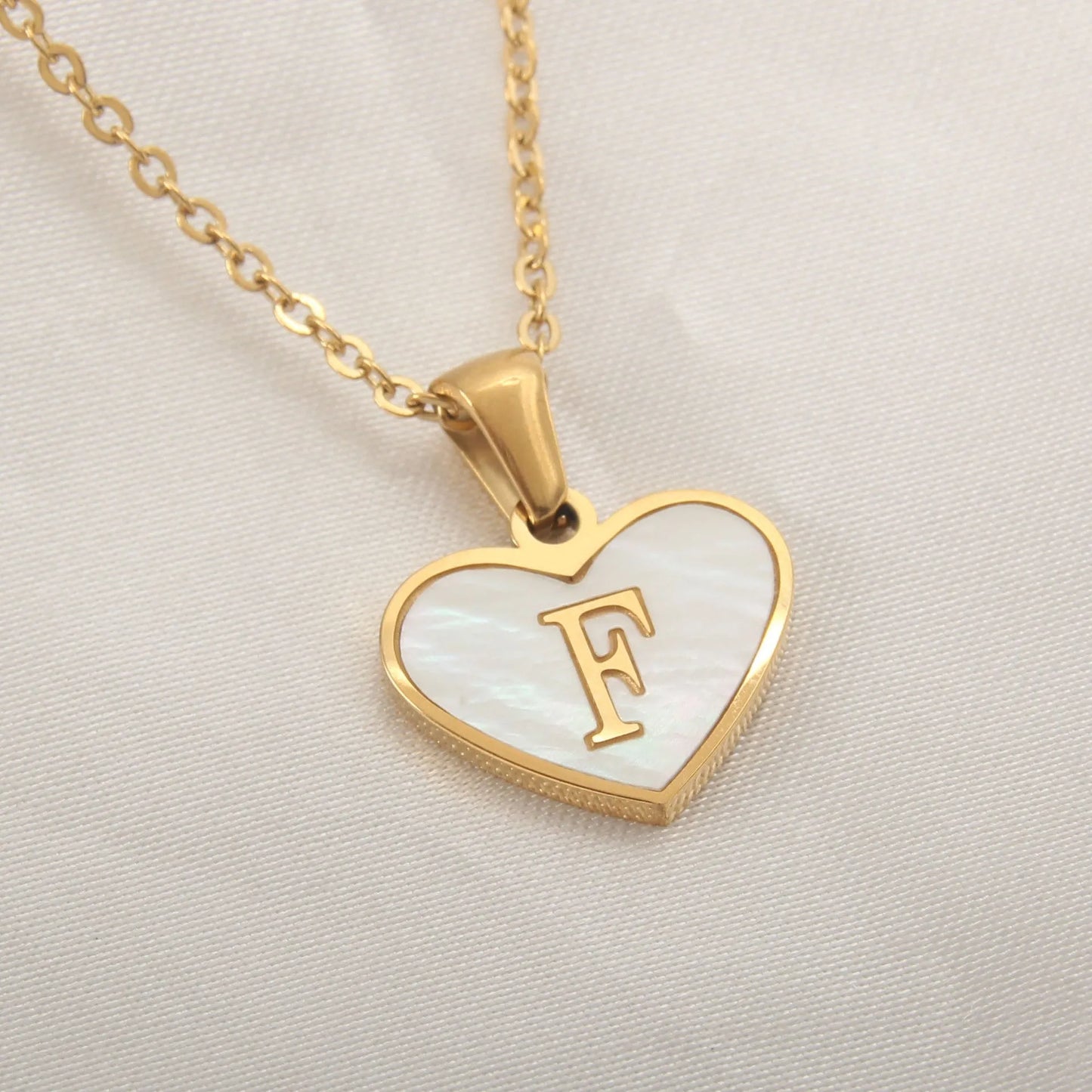 Gold-plated heart necklace with white shell pendant showing letter personalisation option