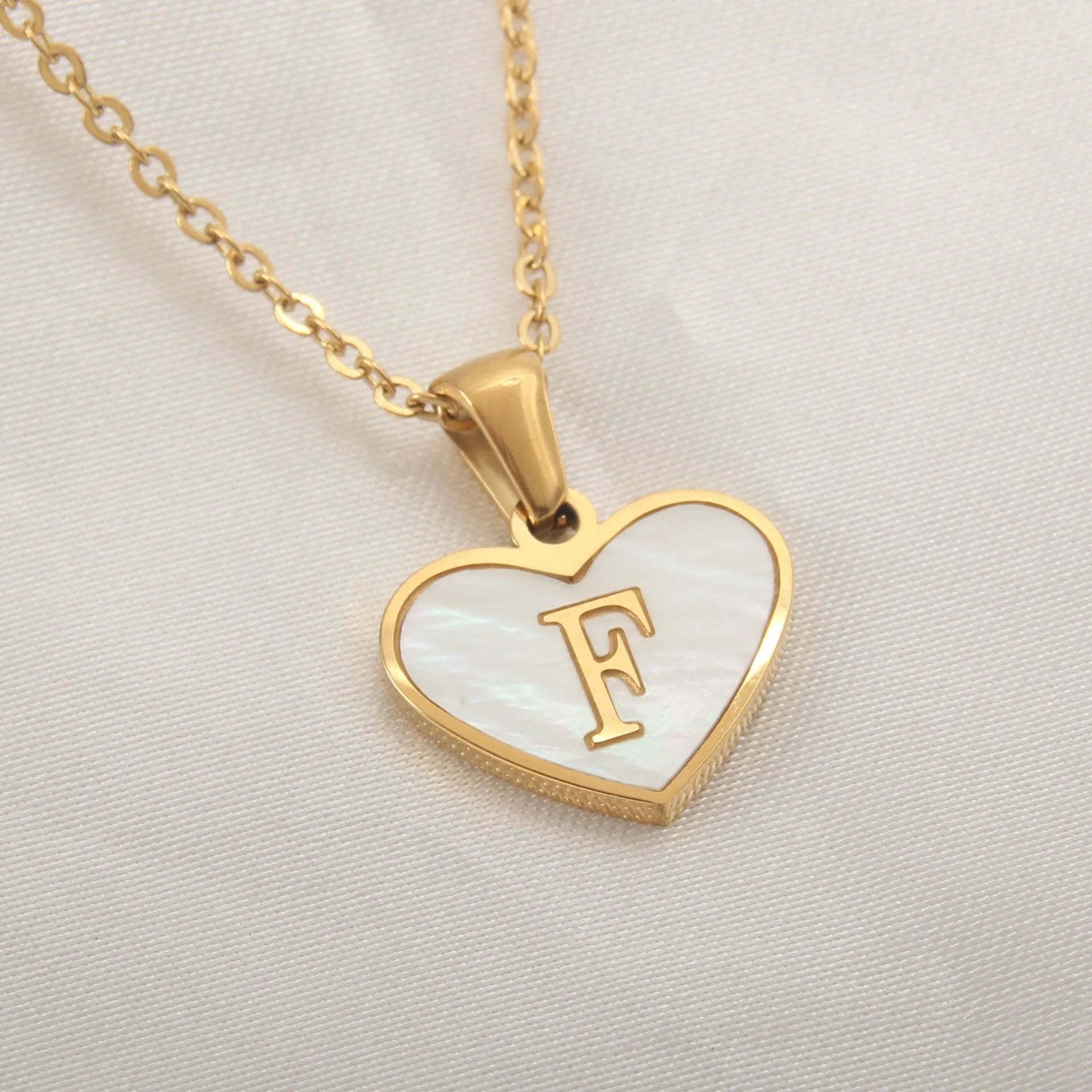 Gold-plated heart necklace with white shell pendant showing letter personalisation option