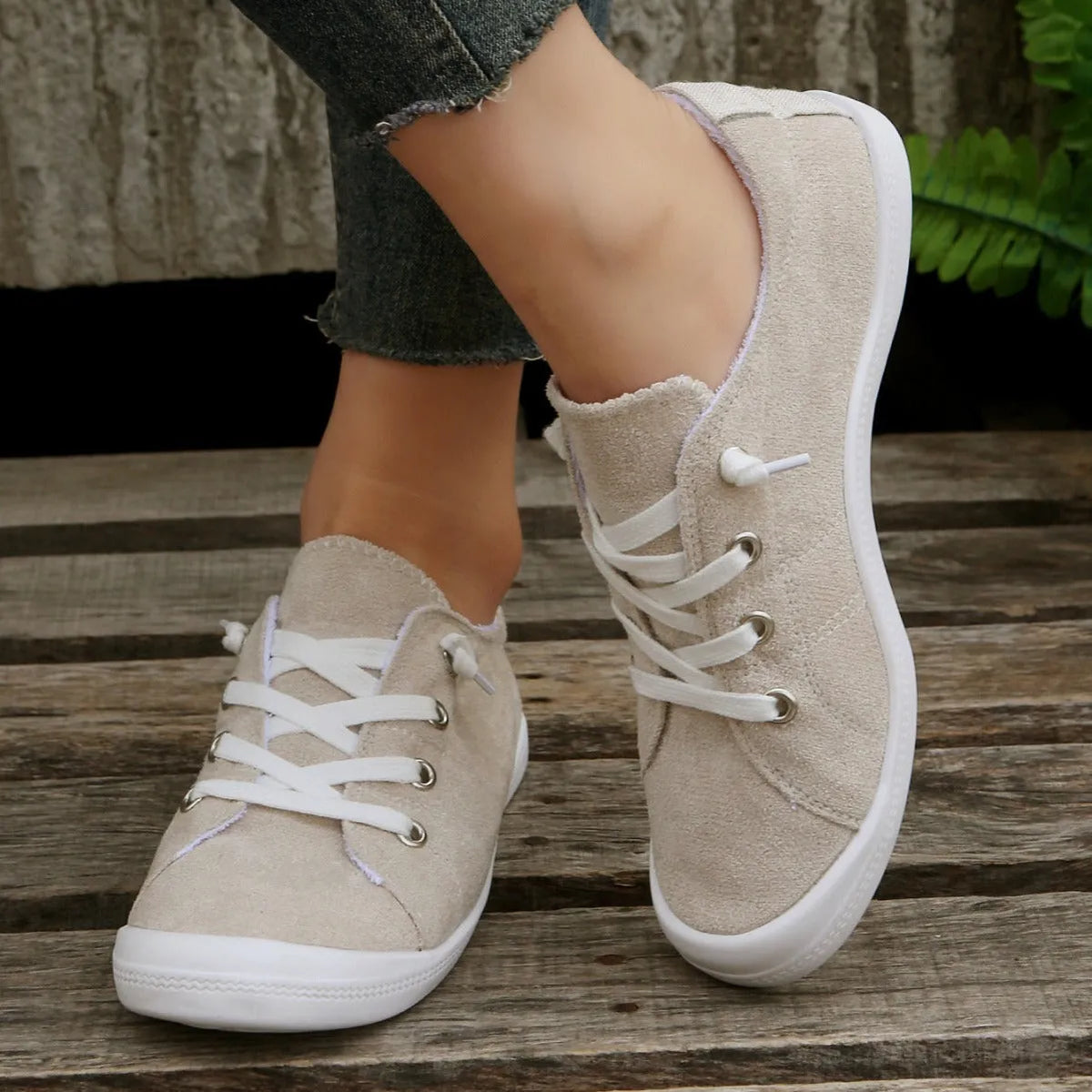 Women's creamy white low-top casual sneaker with fabric upper and rubber sole.