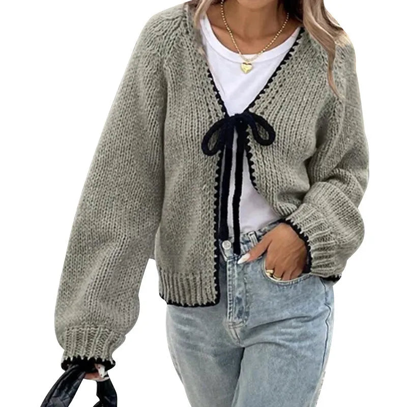 Grey lace-up front cardigan sweater with long sleeves and a crocheted flower detail.
