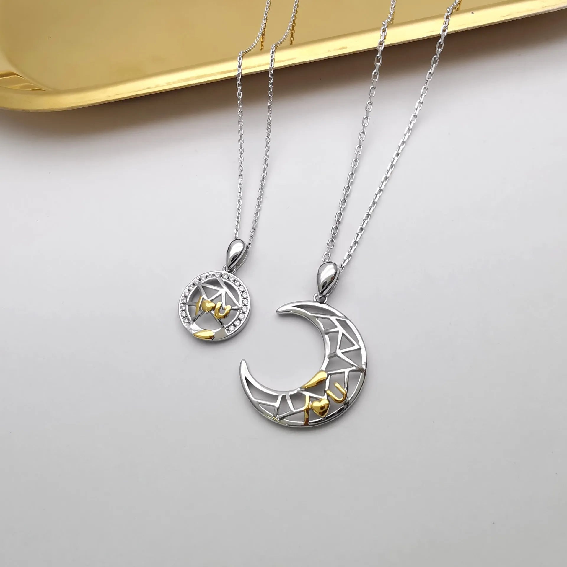 Sun and Moon copper couple's necklaces on a dark background, showing the detailed 4.5cm pendants and cross chain.
