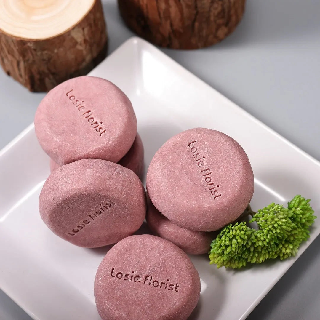 Pink round handmade rosewood grinding soap with roselle and tangerine peel ingredients