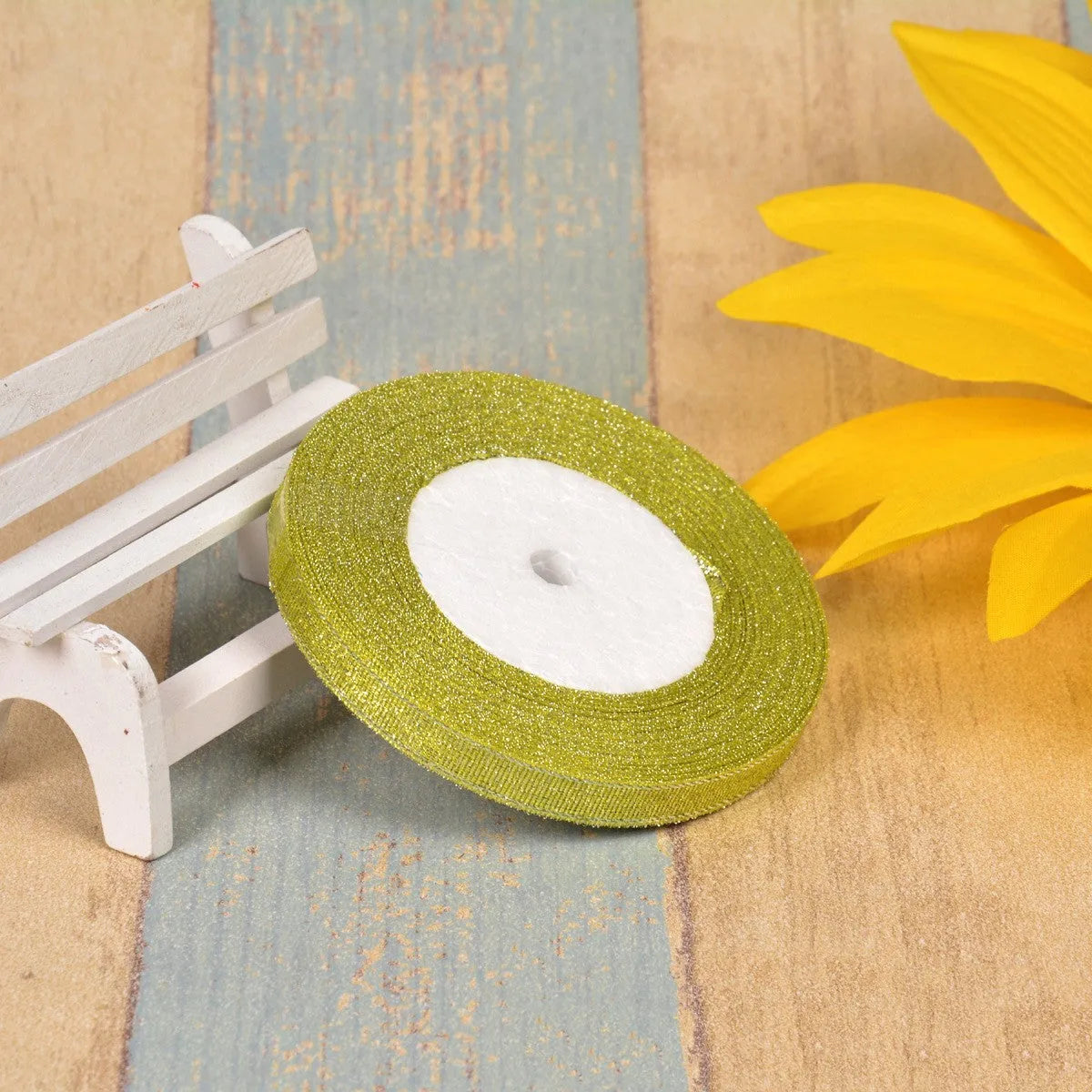 Close-up of green onion patterned ribbon with gold wire on a 25-yard roll, showing 3-points width.