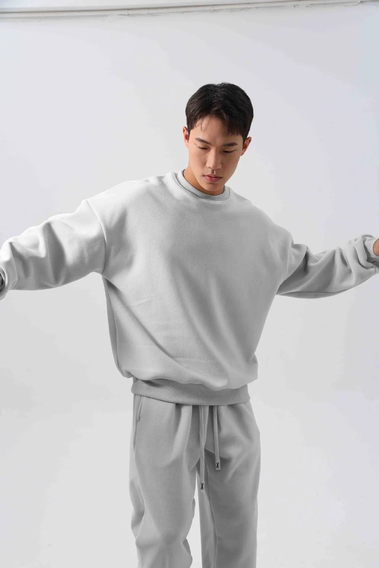Man wearing a loose-fit army green polar fleece tracksuit with a crew neck jacket and matching padded trousers.