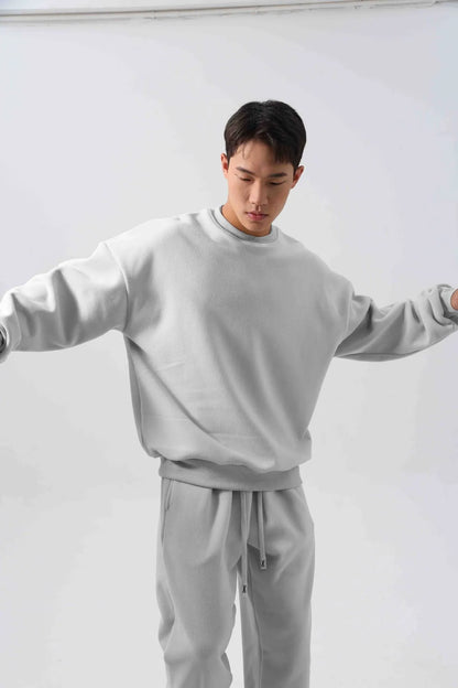 Man wearing a loose-fit army green polar fleece tracksuit with a crew neck jacket and matching padded trousers.