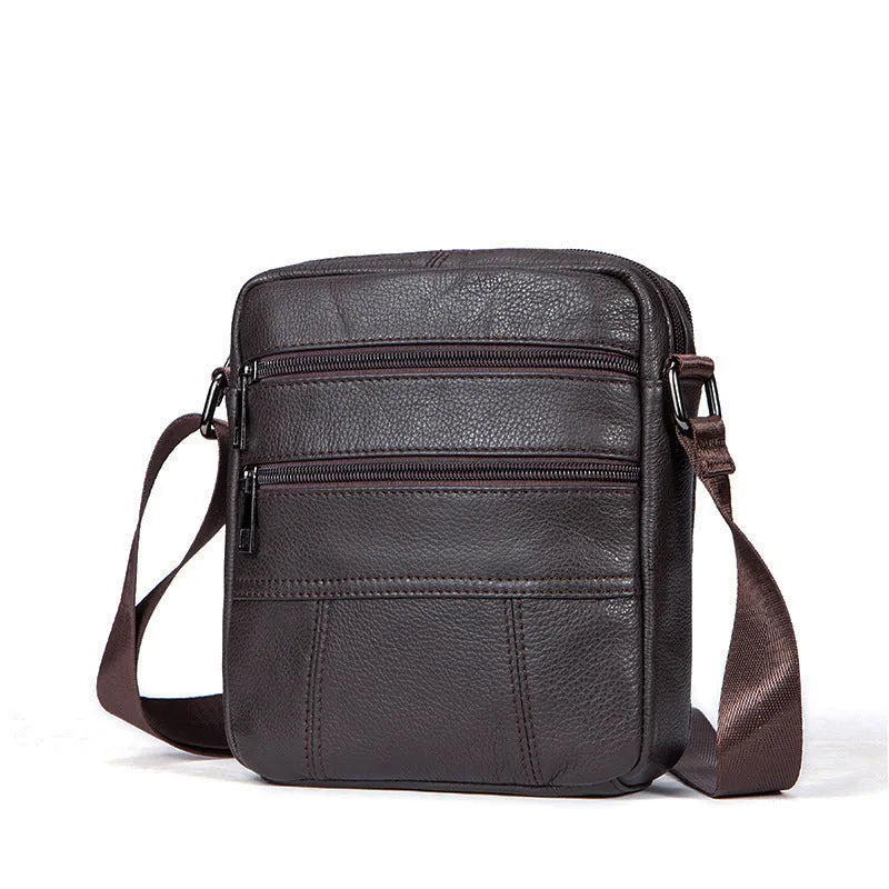 Vertical black genuine cowhide leather shoulder bag with a zip opening and soft handle, shown with internal organiser pockets.