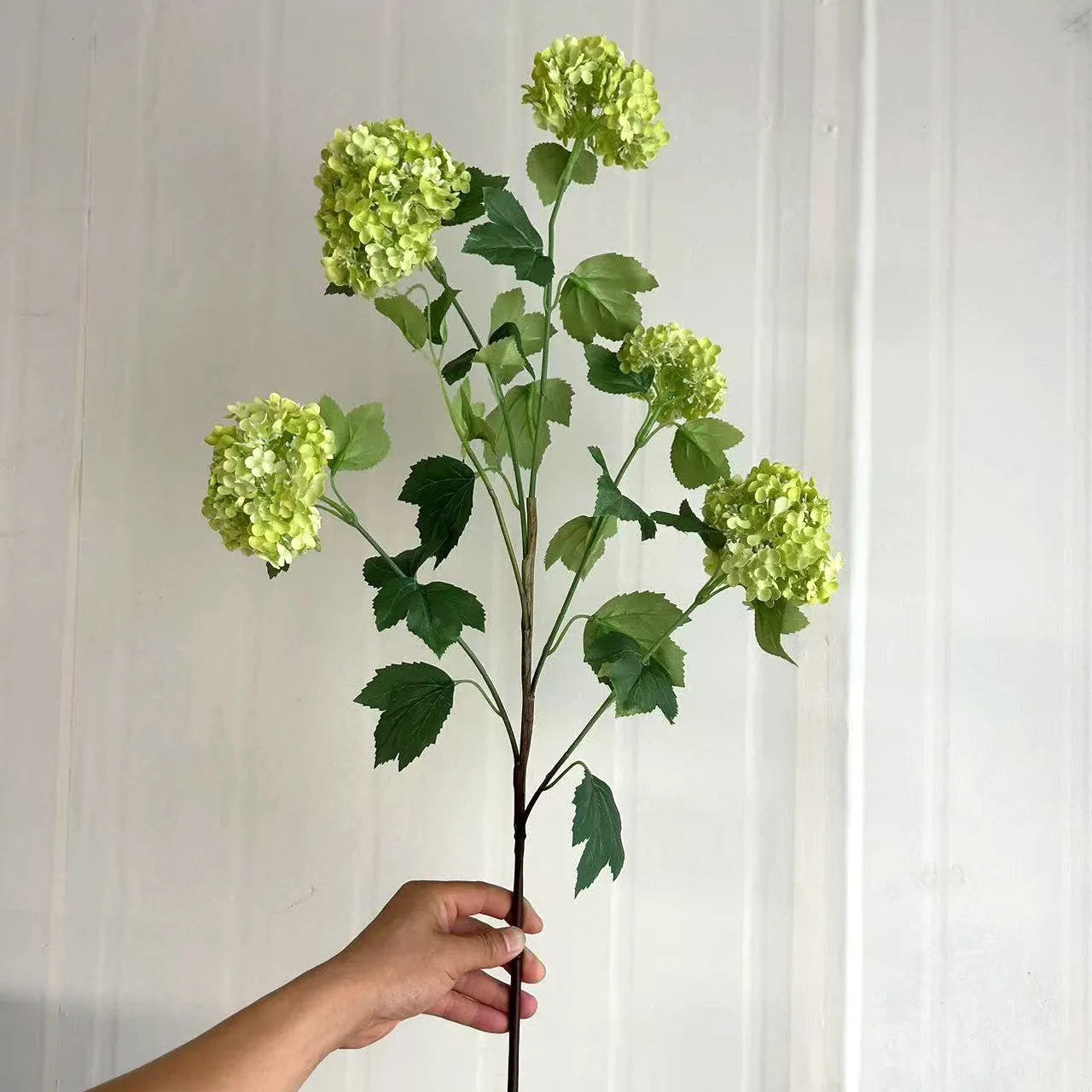 Artificial silk hydrangea flower on long stem branch in white or green colour
