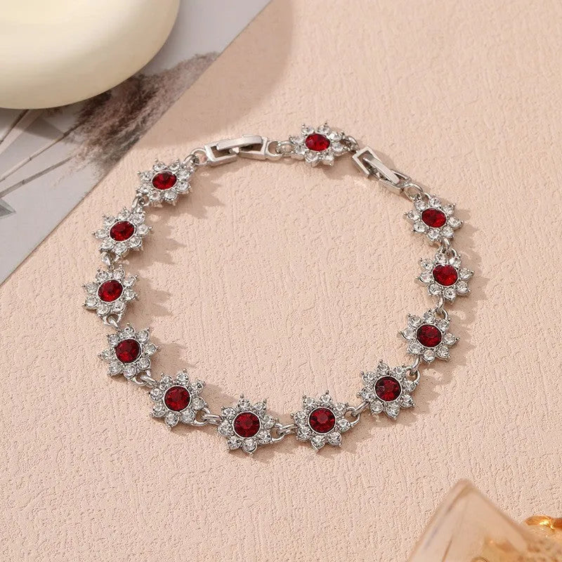 Gold and silver electroplated bracelets with flower charms set with coloured gemstones.