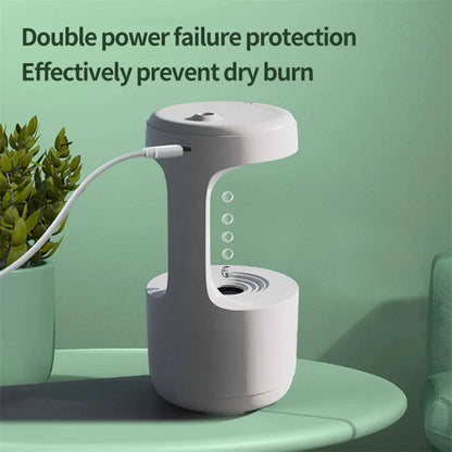 White columnar anti-gravity humidifier with water droplet backflow and LED clock display on a desk.