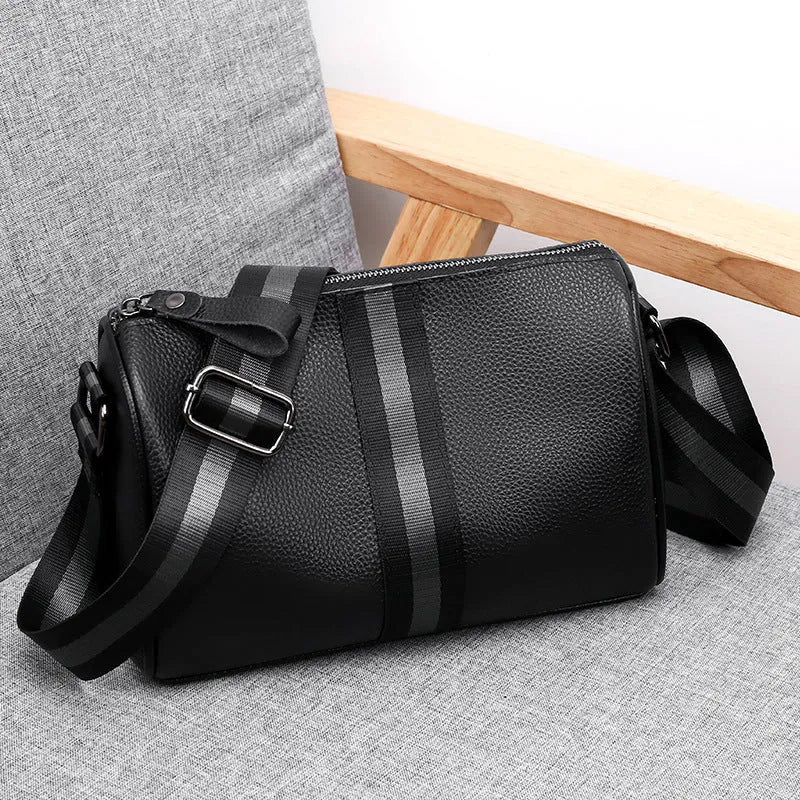 Black genuine leather one-shoulder crossbody bag with large main compartment and polyester lining.