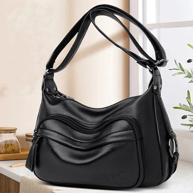 Large blue women's shoulder bag with crossbody strap and multiple internal compartments