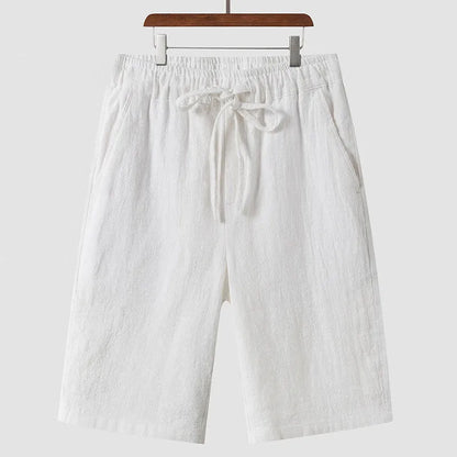 Men's beige linen casual shorts with a loose fit and elastic waistband on a neutral background.