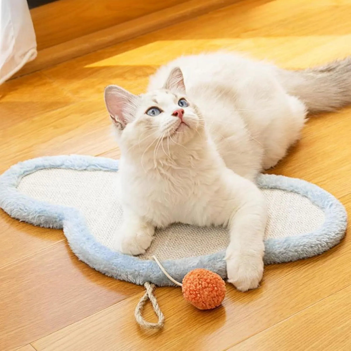 White natural sisal cat scratching mat with sleeping cat cartoon design, mounted on a wall.