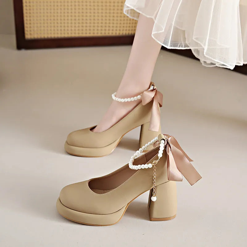 Women's beige preppy style Mary Jane shoes with chunky heel, ankle strap buckle, and pearl detail.