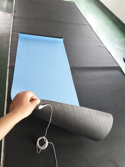 Blue conductive yoga mat with plant pattern, grounding wire, and non-slip surface, rolled partially.