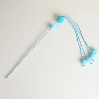Set of four colourful cat stick toys with dangling tassels, showing blue, pink, and purple handles.