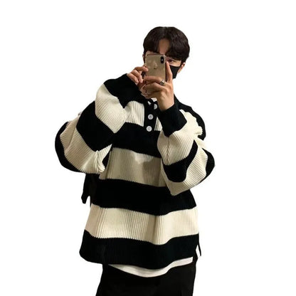 Man wearing a loose grey and black striped long sleeve pullover sweater.