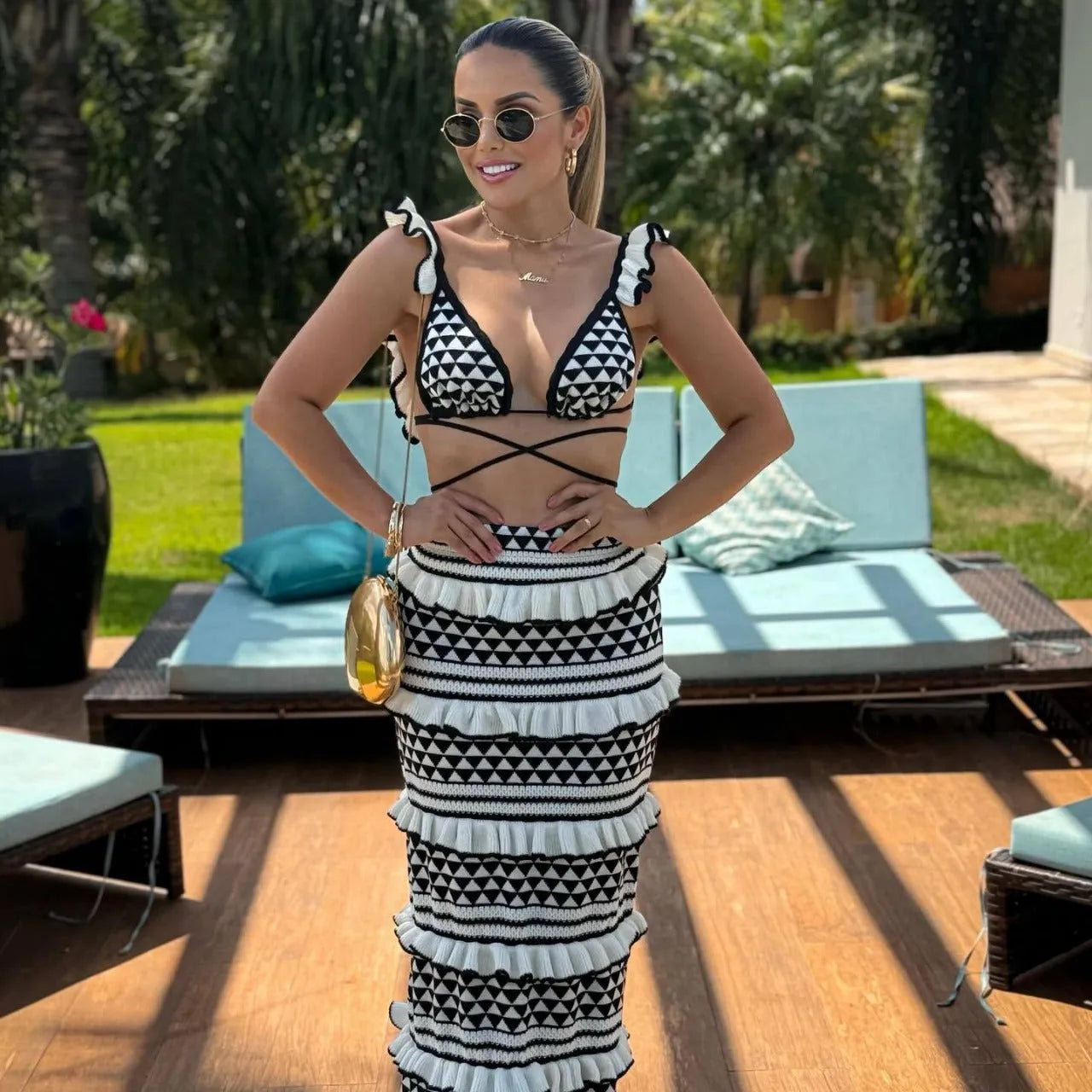 Black and white striped women's bikini set with ruffled top and long skirt on a hanger.