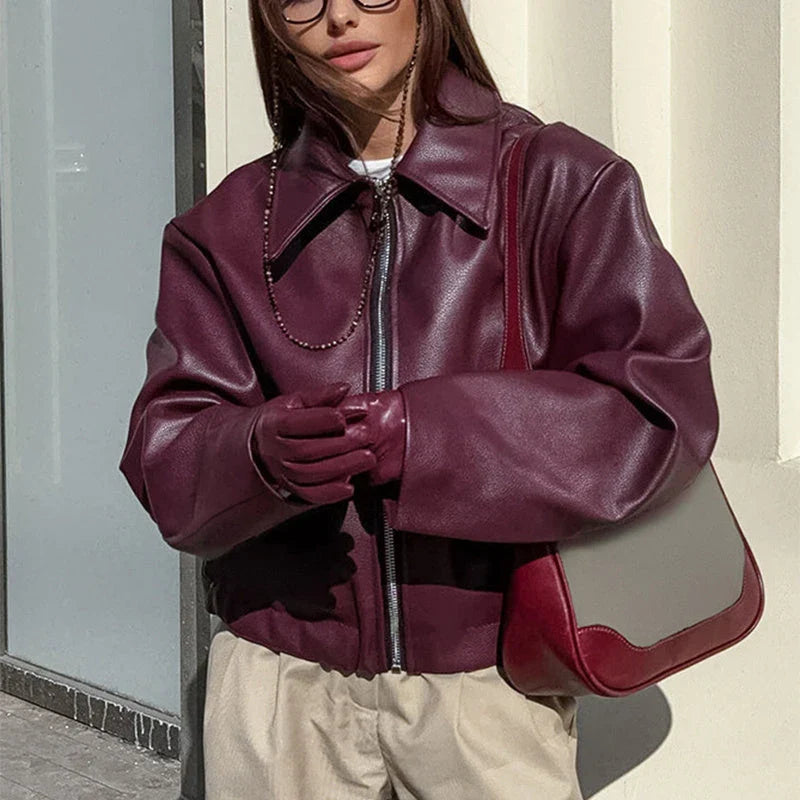 A stylish faux leather jacket with a zipper closure and lapel, available in burgundy and black colors.