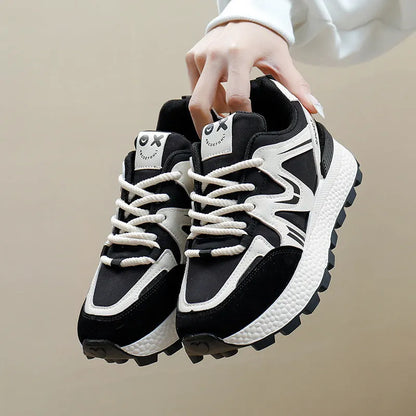 Women's black sports casual shoes with round toe and front lace-up design on a flat heel.