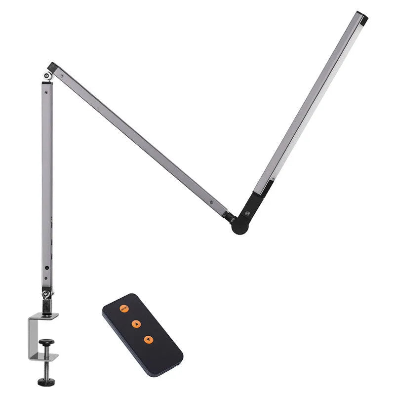 Adjustable aluminium desk lamp with remote control, shown in black with a clip attached to a desk edge.