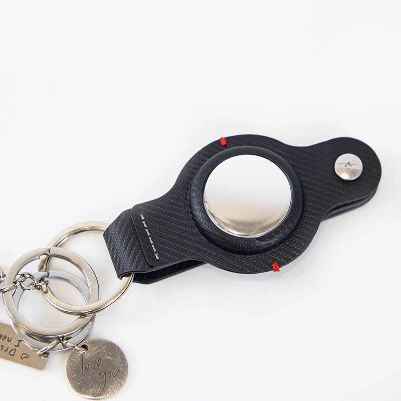 Premium PU leather AirTag keychain holder in black and grey colors for secure tracking of valuables