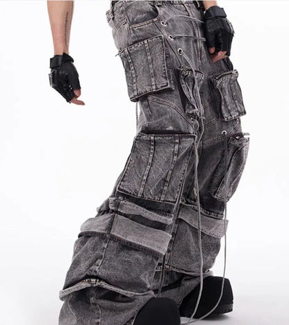 Grey distressed denim overalls jumpsuit with rope stitching on a hanger.