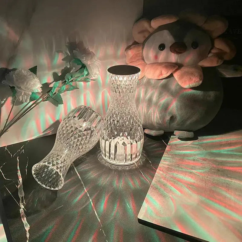 Vase-shaped crystal table lamp with remote control on a bedside table, showing diamond-like glow and USB charging port.