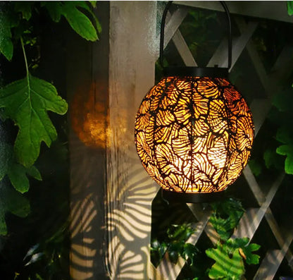 Solar-powered iron courtyard lamp with hollow decorative design and warm white LED lighting