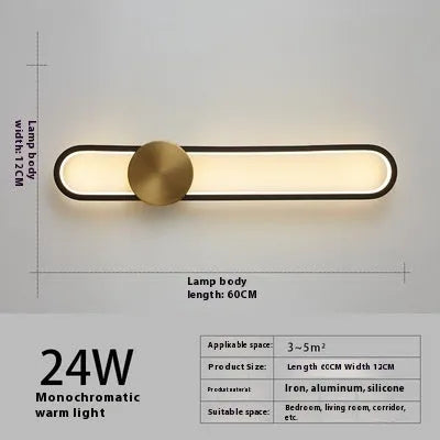 Modern round wall lamp with black iron shade and warm LED light, mounted on a grey wall.
