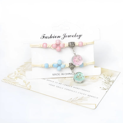 Close-up of a hand-woven bracelet with a large 1.4cm glass bead containing colourful dried flowers.
