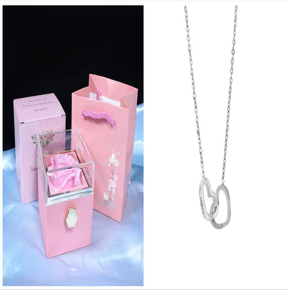 Rotating rose jewellery gift box with a preserved red rose under a clear acrylic dome, showing the interior rotating drawer.