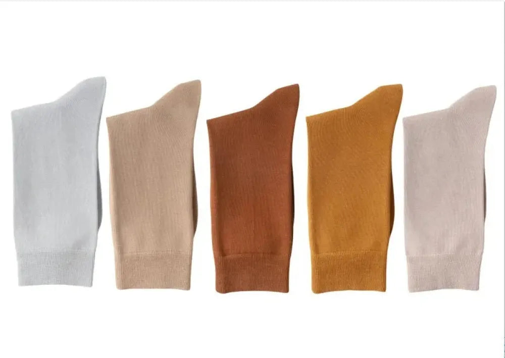 Pair of solid-colour men's mid-calf socks made from combed cotton on a wooden background
