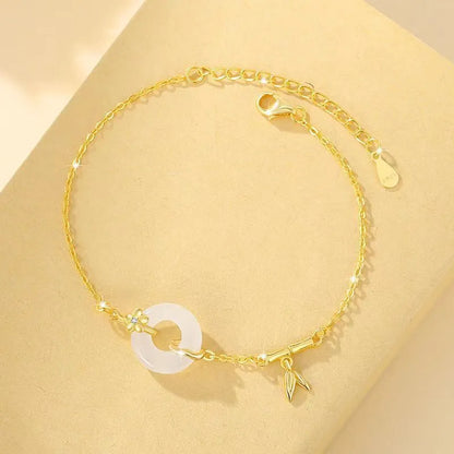 Women's silver and gold electroplated bracelet with peace buckle charm and white chalcedony stone.