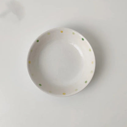 Japanese-style dot pattern porcelain plates and bowls in irregular oval and round shapes on a table.